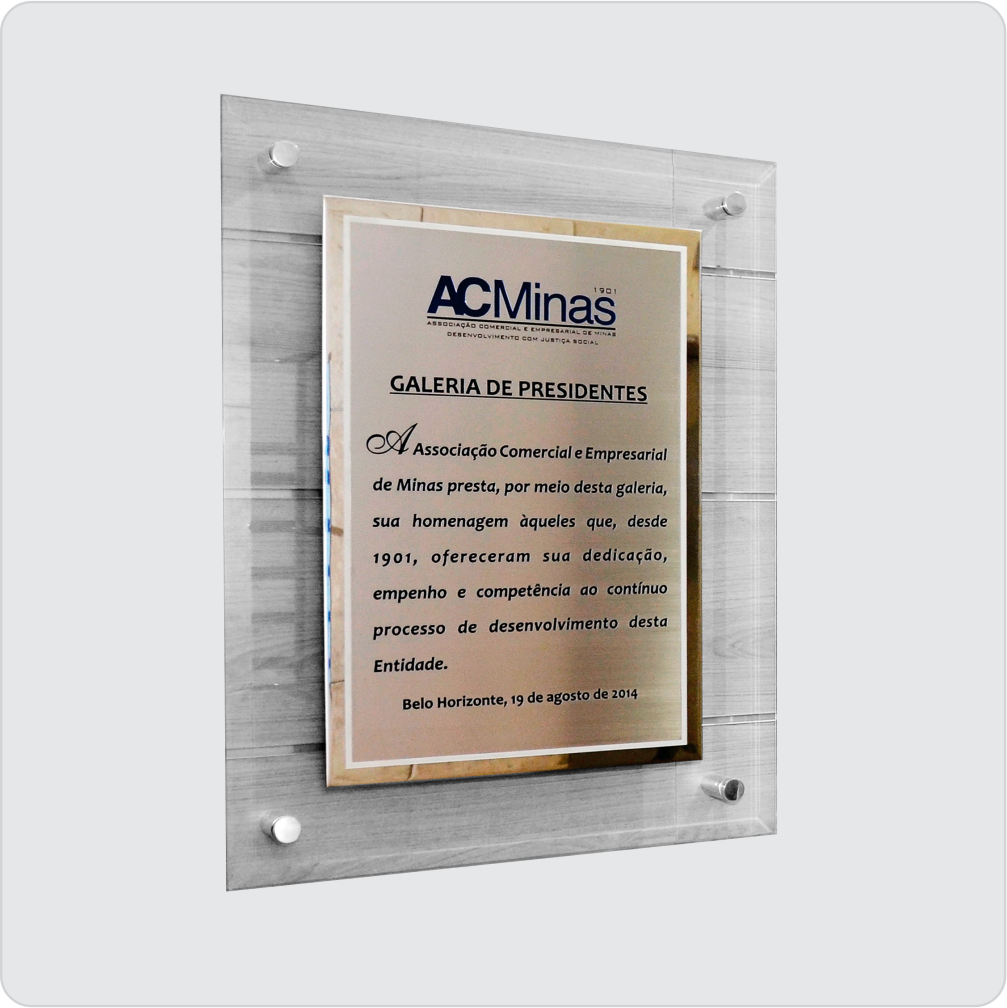 Placa gravada no processo de corrosão, sublimação ou UV em aço inox, sobreposta por placa espelhada fixada no vidro